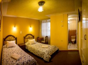 une chambre d'hôtel avec deux lits et une salle de bain dans l'établissement Hostal Cabaña María Inn Inkahoteles, à Arequipa