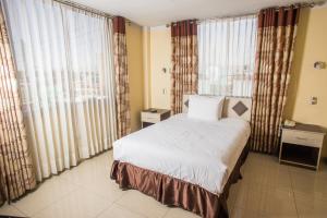 une chambre avec un grand lit et de grandes fenêtres dans l'établissement Hostal Cabaña María Inn Inkahoteles, à Arequipa