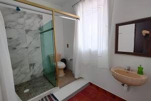 a bathroom with a glass shower and a sink at Encasa - Román 26 in Poza Rica de Hidalgo +12 photos