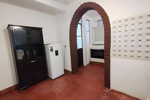 an archway in a room with a refrigerator and a kitchen at Encasa - Román 26 in Poza Rica de Hidalgo