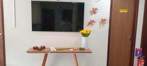 a table with a vase of flowers and a mirror at Pousada Tropical Maragogi in Maragogi