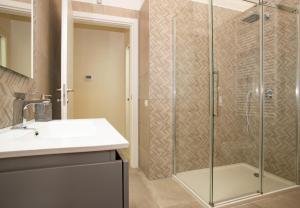 a bathroom with a sink and a glass shower at Urban Suite - The Fab Stay in Brindisi