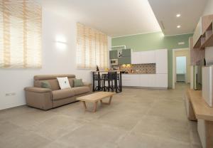 a living room with a couch and a table at Urban Suite - The Fab Stay in Brindisi +9 photos