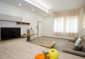 a living room with a couch and a television and a table at Urban Suite - The Fab Stay in Brindisi