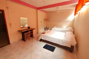 a bedroom with a bed and a desk and a mirror at Encasa - Palm 206 in Poza Rica de Hidalgo