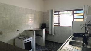 a small kitchen with a counter and a sink at A Nossa Casinha no Bosque - 4min do Parque Capivari in Campos do Jordão +73 photos