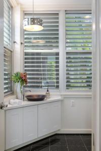 a bathroom with a sink and a window with blinds at Zen Villa in Key West +50 photos