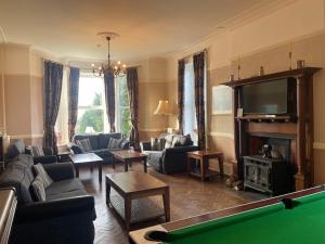 a living room with a pool table and a tv at Highland Moors in Llandrindod Wells