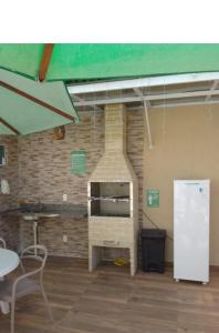 - un four en briques dans une pièce avec une table et des chaises dans l'établissement Flat Makaranduba Centro Porto de Galinhas,dois quartos, à Porto de Galinhas