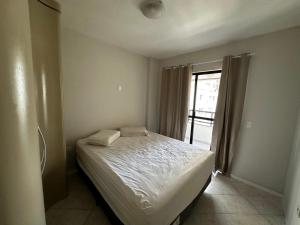 a bedroom with a bed in a room with a window at APT ALUGUEL Praia central in Balneário Camboriú