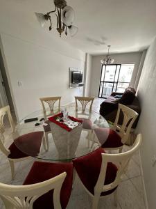 a living room with a glass table and chairs at APT ALUGUEL Praia central in Balneário Camboriú