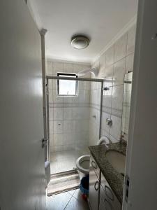 a bathroom with a shower with a toilet and a sink at APT ALUGUEL Praia central in Balneário Camboriú +3 photos