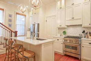a kitchen with white cabinets and a kitchen island at Katie's Cottage in Natchez, Charming Historic Home in Natchez