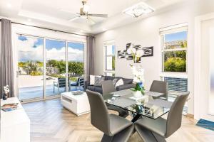 a living room with a glass table and chairs at Romantic Escape, Walk to Beach, Pool, Hammock in Long Bay Hills