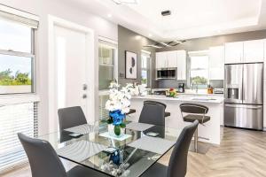 a dining room with a table and chairs and a kitchen at Romantic Escape, Walk to Beach, Pool, Hammock in Long Bay Hills