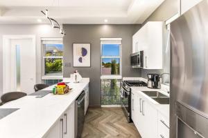 a kitchen with white cabinets and a counter top at Romantic Escape, Walk to Beach, Pool, Hammock in Long Bay Hills