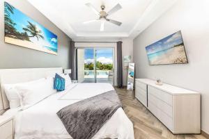 a bedroom with a bed and a ceiling fan at Romantic Escape, Walk to Beach, Pool, Hammock in Long Bay Hills