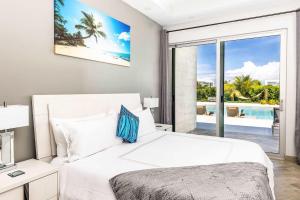 a bedroom with a bed and a view of the ocean at Romantic Escape, Walk to Beach, Pool, Hammock in Long Bay Hills