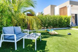 a blue chair and a glass table in a yard at Romantic Escape, Walk to Beach, Pool, Hammock in Long Bay Hills