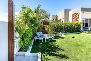 a garden with a chair and a table in a yard at Romantic Escape, Walk to Beach, Pool, Hammock in Long Bay Hills