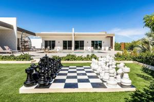 a chess board on a lawn in front of a house at Romantic Escape, Walk to Beach, Pool, Hammock in Long Bay Hills