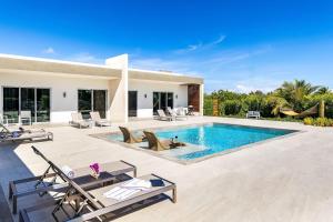 a villa with a swimming pool and a house at Romantic Escape, Walk to Beach, Pool, Hammock in Long Bay Hills