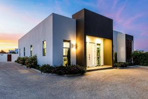 a white building with a sunset in the background at Romantic Escape, Walk to Beach, Pool, Hammock in Long Bay Hills