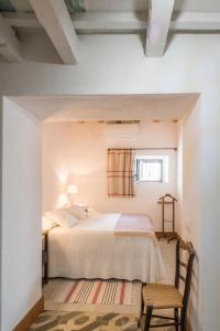 a bedroom with a bed and a chair and a window at La Veleta de Vejer in Vejer de la Frontera