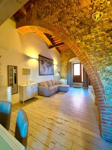 a living room with a couch and a stone wall at Casa Leo in Capoliveri