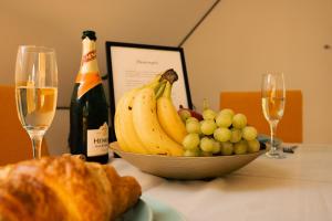 a bowl of fruit on a table with glasses of wine at Ferienwohnung Viktring 4-5 Pers. in Klagenfurt