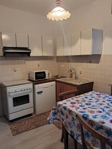 a kitchen with a table and a stove and a microwave at Alloggio Grande Joséphine in Oulx