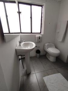 a white bathroom with a sink and a toilet at Donde Emilio in Pereira