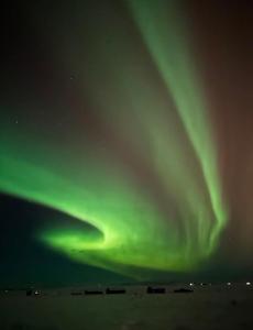 una imagen de la aurora boreal en el cielo en Blue View Cabins, en Reykholt