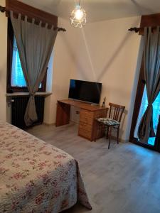 a bedroom with a bed and a flat screen tv at Alloggio Grande Joséphine in Oulx
