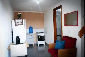 a small kitchen with a red chair and a stove at Pousada Ametista Sorriso in Sorriso