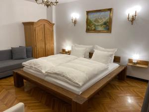 a large white bed in a room with a couch at Casa Tei in Turnişor