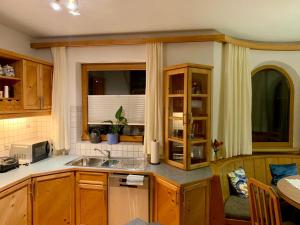 una cucina con armadi in legno, lavandino e finestra di Fewo Riefe a Zams