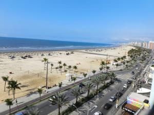 a view of a beach with palm trees and cars at Espaço Shalom in Praia Grande
