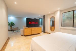 a hotel room with a bed and a television at Provenza Lux Apartment l Guest Friendly l Fast Wifi l 9 Guest in Medellín