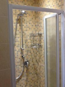 une douche avec une porte vitrée dans une salle de bain dans l'établissement Casa Sangion, à Caorle