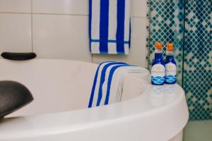 three bottles of spirits sitting on the edge of a bath tub at Pousada Estrela da Luz Beach in Ceará-Mirim +44 photos