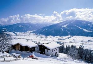 a house in the snow with a mountain in the background at Berggasthof-Ferienbauernhof Habersatt in Altenmarkt im Pongau +15 photos