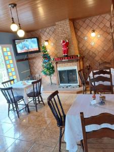 a dining room with a christmas tree and a fireplace at ANC BOSQUE - 4min do Parque Capivari in Campos do Jordão
