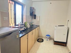 a kitchen with a counter and a sink and a refrigerator at 1 BHK near Calangute Beach A1-201 in Calangute