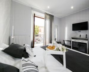 a living room with a bed and a tv at Little House AURORA in Melfi