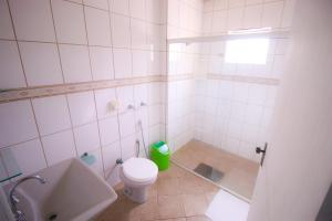 une salle de bain blanche avec toilettes et douche dans l'établissement Premier Palace Hotel, à Araranguá