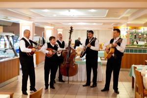 a group of men playing instruments in a restaurant at Hotel Dražica - Hotel Resort Dražica in Krk