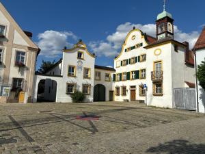 a building with a clock tower in a courtyard at Ferienwohnung Allersberg beim Rothsee in Allersberg