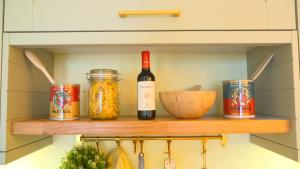 a shelf with a bottle of wine and jars of food at Casa Mia in Tremezzo +17 photos