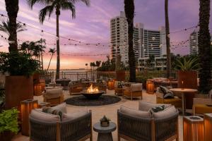 a patio with chairs and a fire pit with a sunset at The Ritz-Carlton, Sarasota in Sarasota